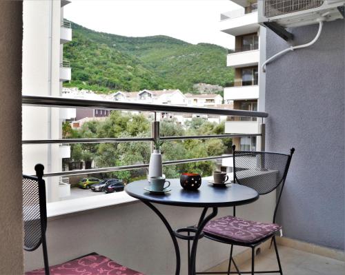 einen Tisch und Stühle auf einem Balkon mit Aussicht in der Unterkunft Yeshill Apartments in Budva