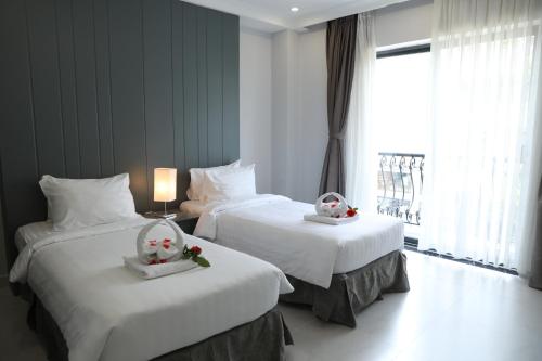 ein Hotelzimmer mit 2 Betten mit Blumen darauf in der Unterkunft Fide Hotel in Ho-Chi-Minh-Stadt