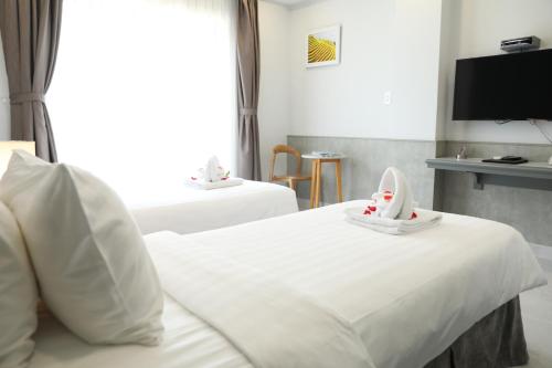 ein Hotelzimmer mit 2 Betten mit Schuhen darauf in der Unterkunft Fide Hotel in Ho-Chi-Minh-Stadt