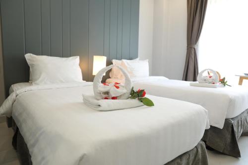 two beds with white sheets with hello kitty decorations on them at Fide Hotel in Ho Chi Minh City