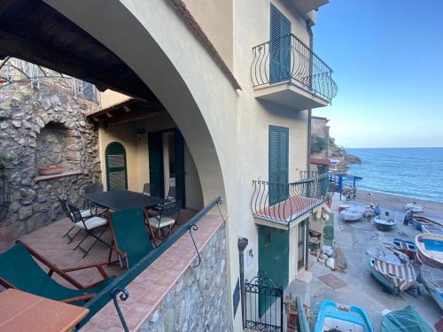 balcón con mesa, sillas y vistas al océano en La casa al mare, en Nerano