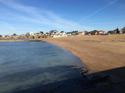 a view of the beach with houses in the background at Gîte du Petit Poucet in Saint-Hilaire-de-Riez