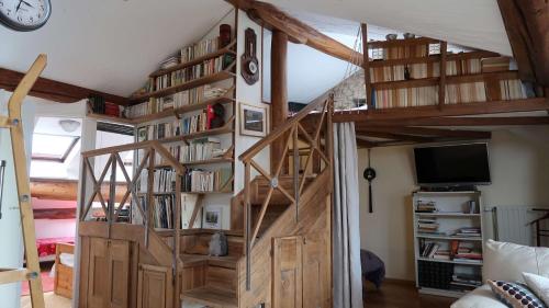 a room with a wooden staircase with bookshelves at La Casa Victoria -Stanislas area -Suite 65m2 OR Loft 75m2 in Nancy
