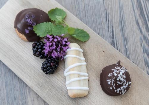 a wooden cutting board with two donuts and blackberries at Skovshoved Hotel in Charlottenlund