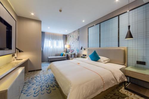 a bedroom with a large bed and a television at Warm Yes Business Hotel in Guangzhou