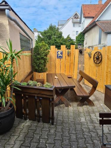 a patio with a wooden table and a wooden fence at Gasthof Wolfs Stuben in Reichenbach an der Fils