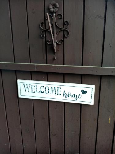 a welcome home sign hanging on a wooden wall at Apartment Goisernperle in Bad Goisern