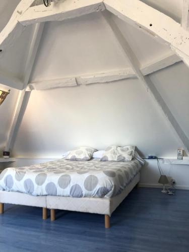 un lit dans une chambre blanche avec un cadre de lit dans l'établissement Maison de pécheur 4 chambres centre ville 10 min de la plage Good Mindset, à Trouville-sur-Mer