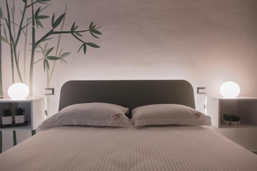 a white bedroom with a large bed with two pillows at Elly's B&B in Portici
