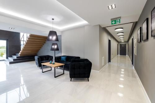 a lobby with couches and a table and stairs at Apartamenty N7 in Darłówko