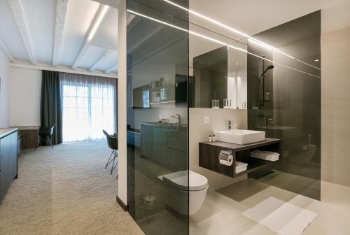 a bathroom with a toilet and a sink at Hotel Spitzerberg by b-smart 