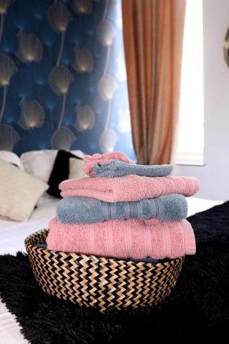 - une pile de serviettes dans un panier sur un lit dans l'établissement Residence Monsigny, à Boulogne-sur-Mer