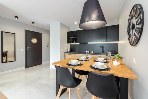 a kitchen and dining room with a wooden table and chairs at Apartamenty N7 in Darłówko