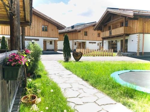 a yard with a stone walkway and a house at Sieglhub Chalets - Appartements - Hotel in Flachau