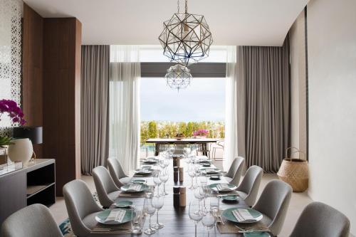 a dining room table with chairs and a large window at Jumeirah at Saadiyat Island Resort in Abu Dhabi