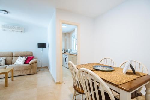 comedor y sala de estar con mesa y sillas en Hostly Lagar Center-Fibre-Parking optional-CLess en Sevilla