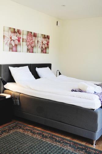 a bed in a room with a black bed frame at Kågeröds Värdshus Tre Stjärnor in Kågeröd