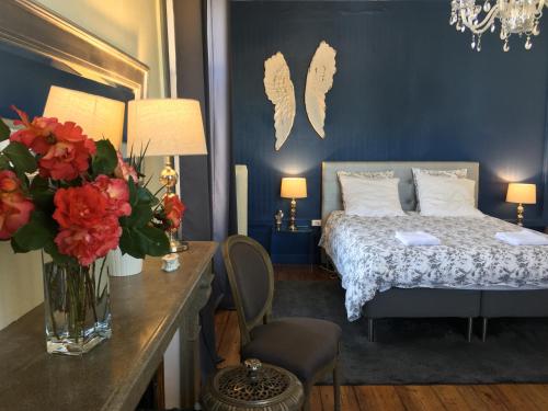ein Schlafzimmer mit einem Bett und einem Tisch mit einer Blumenvase in der Unterkunft La Maison de famille in Boën