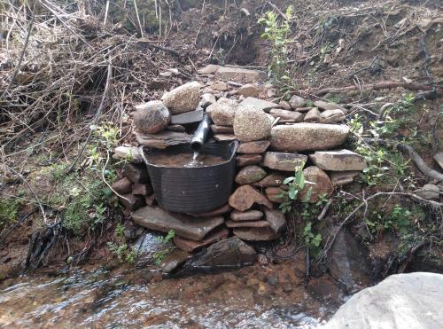 a stone wall with a bucket on top of rocks at Casa Rural El Arroyo in Sotoserrano