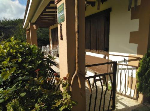 a gate to a building with a table and chairs at Casa Rural El Arroyo in Sotoserrano