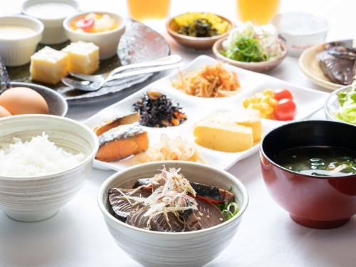 una mesa con platos de comida y tazones de comida en APA Hotel Shin Osaka Ekimae, en Osaka