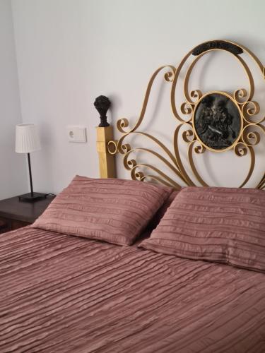 a bedroom with a bed with a gold head board at 1930 Diecinueve Treinta "Diseño, historia y confort en el centro de Gijón" in Gijón