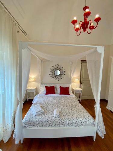 a bedroom with a white canopy bed with red pillows at La Via della Giudecca in Siracusa