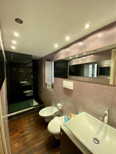 a bathroom with two toilets and a sink and a mirror at La Via della Giudecca in Siracusa