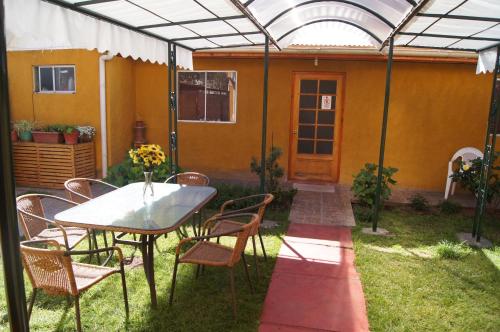 a patio with a table and chairs and a house at Tierra Noble tu mejor opcion en ahorro, B, PRIVADO, A,ACONDICIONADO, CENTRAL in Santa Cruz