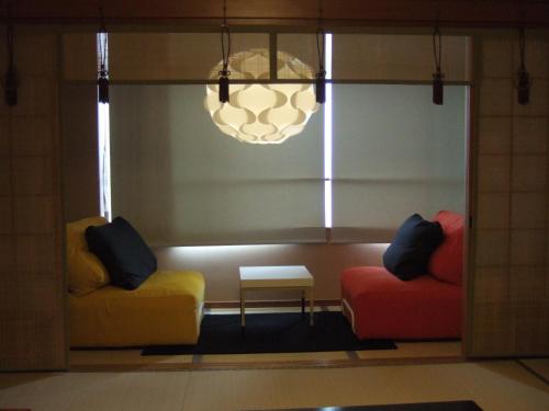 two chairs and a table in a room with a window at Oyado Koto No Yume in Takayama