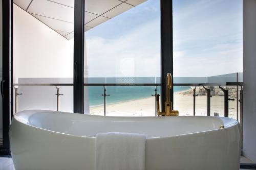 a bath tub in a bathroom with a view of the beach at Jumeirah at Saadiyat Island Resort in Abu Dhabi