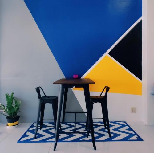a table and two chairs in front of a wall at Nap at 265 Donmeaung in Bangkok