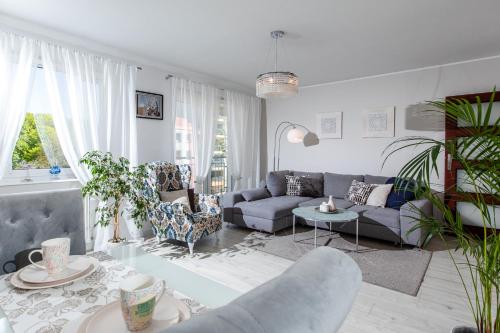 een woonkamer met een bank en een tafel bij Apartamenty Latarnia Morska – Sun Seasons 24 in Kołobrzeg