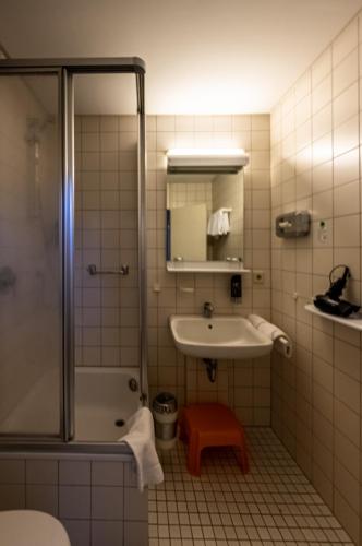 a bathroom with a sink and a shower at Waldhaus Jakob in Konstanz