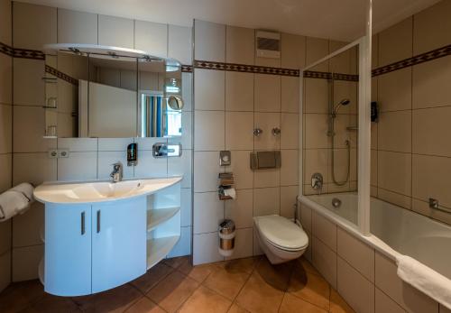 a bathroom with a sink and a tub and a toilet at Waldhaus Jakob in Konstanz