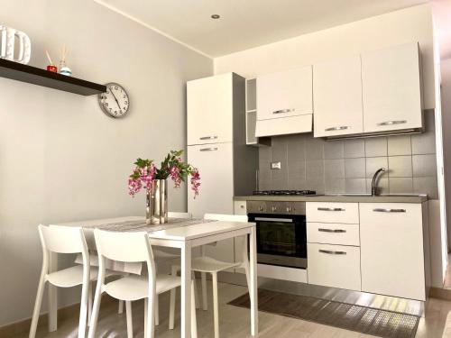 a kitchen with a table and chairs and a clock at Appartamento D & D in Niscemi