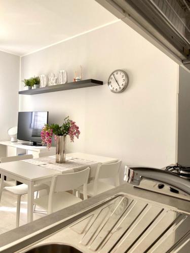 a dining room with a table and a clock on the wall at Appartamento D & D in Niscemi