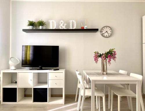 a white dining room with a table and a tv at Appartamento D & D in Niscemi