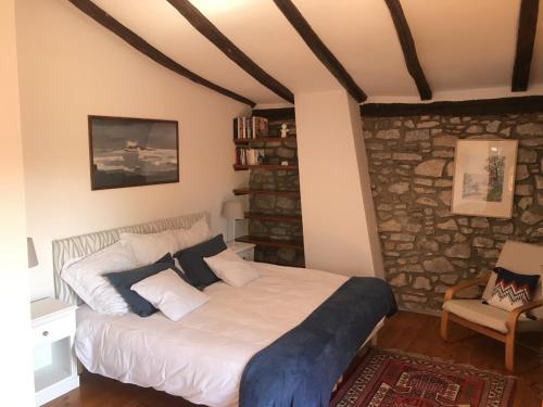 1 dormitorio con cama y pared de piedra en Chambres d'hôtes GELA ITSASOA Baie, en Ciboure