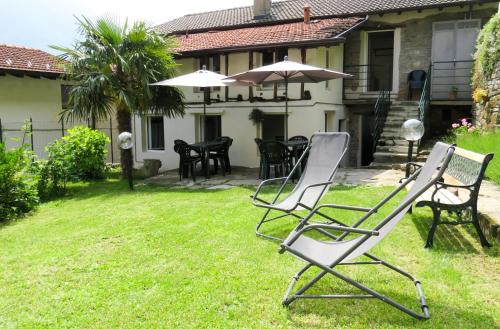 dos sillas de jardín sentadas en el patio de una casa en Rivacanze Apartments en Laglio