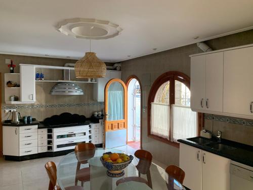 a kitchen with a table with a bowl of fruit on it at La Quinta - La Barrosa in Chiclana de la Frontera