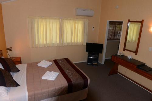 a hotel room with a bed and a television at Classic Motel in Hamilton