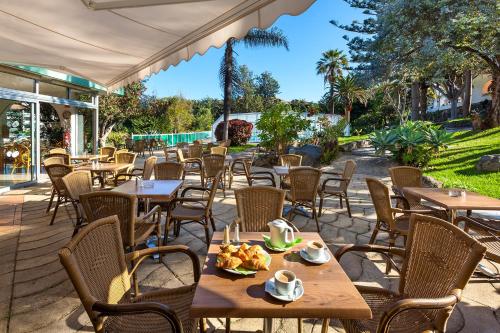 un restaurant en plein air avec des tables et des chaises et une table et des chaises dans l'établissement Parque Vacacional Eden, à Puerto de la Cruz