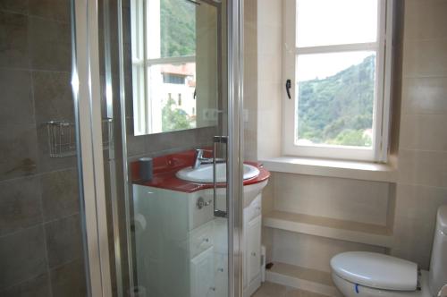 bagno con lavandino, servizi igienici e finestra di La Casona de Narganes a Narganes
