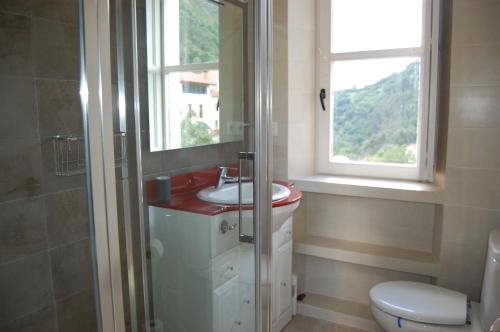 a bathroom with a sink and a toilet and a window at Gestiona2R - Narganes Mar y Montaña, ideal familias in Narganes