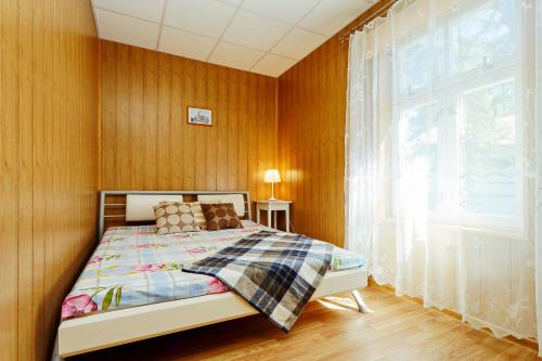 a bedroom with a bed and a large window at Holiday Home Viktorija B in Jūrmala