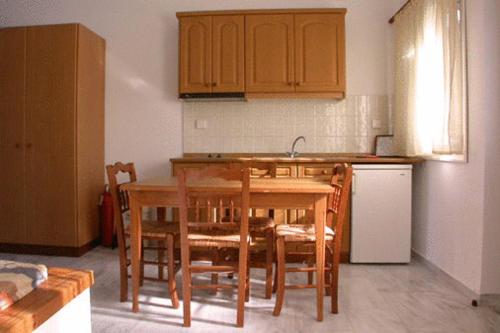 cocina con mesa, sillas y fregadero en Studios Akrogiali, en Kyparissia