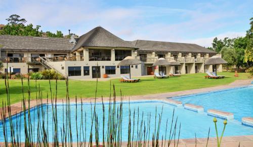 une grande maison avec une piscine en face de celle-ci dans l'établissement Piekenierskloof Mountain Resort by Dream Resorts, à Citrusdal