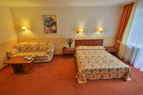 a hotel room with two beds and a couch at Ukraina Hotel in Cherkasy
