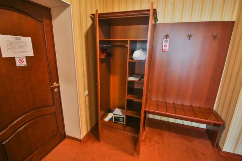 a room with a closet with a wooden door at Ukraina Hotel in Cherkasy